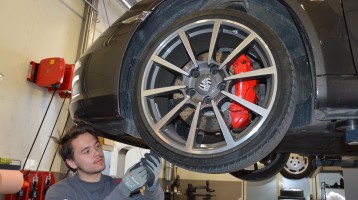 Bild på tekniker Andreas Karlsson som arbetar med en Porsche hos Porsche Service Center Haninge.
