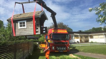 Assistancekårens bärgningsbil lyfter en lekstuga med sin kran.