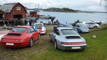Bild från Yxlö som ligger vid havet utanför Stockholm. Porschar i olika färger står parkerade vackert vid havet.